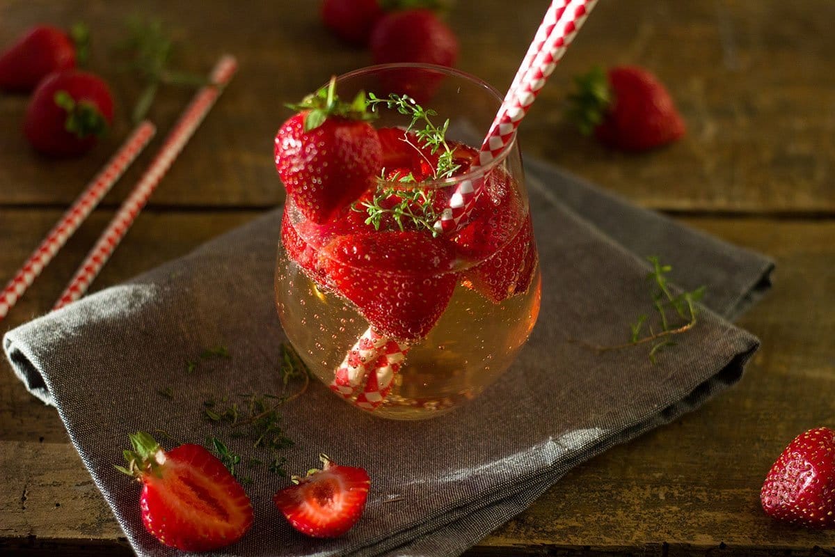 Drink with strawberries and paper straws inside the the glass
