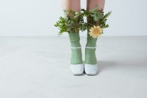 Leaves and a yellow flower on a person's eco-friendly socks