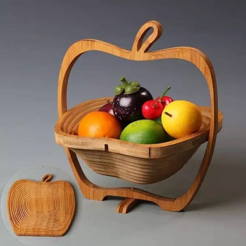 Collapsible bamboo fruit basket flat on surface and propped up with fruits in the basket