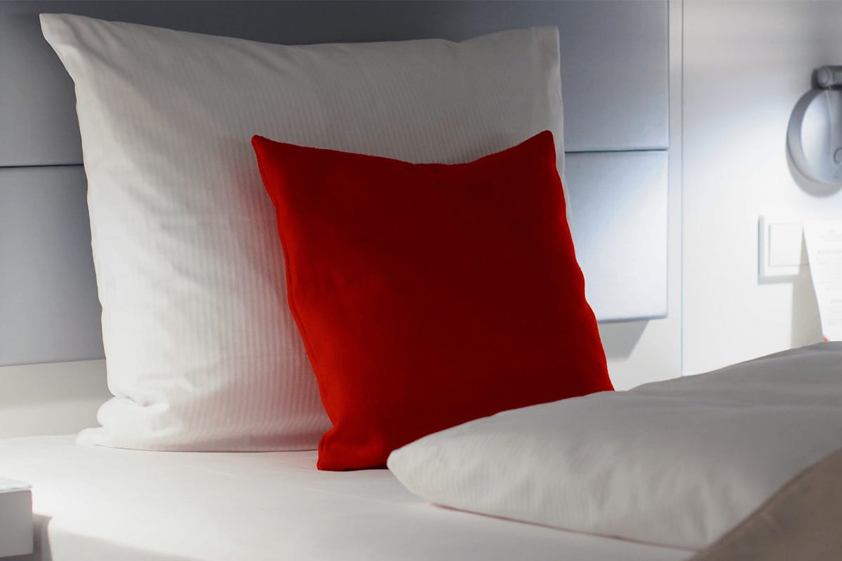 White and red bamboo pillows on a bed