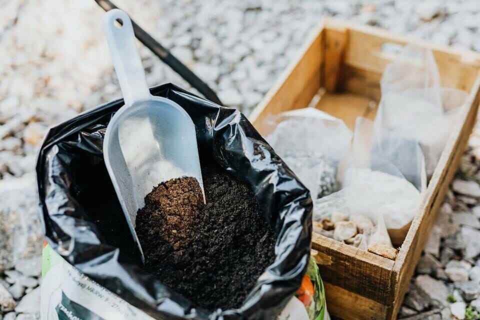 Alkaline soil in a sack with a crate of fertilizers.