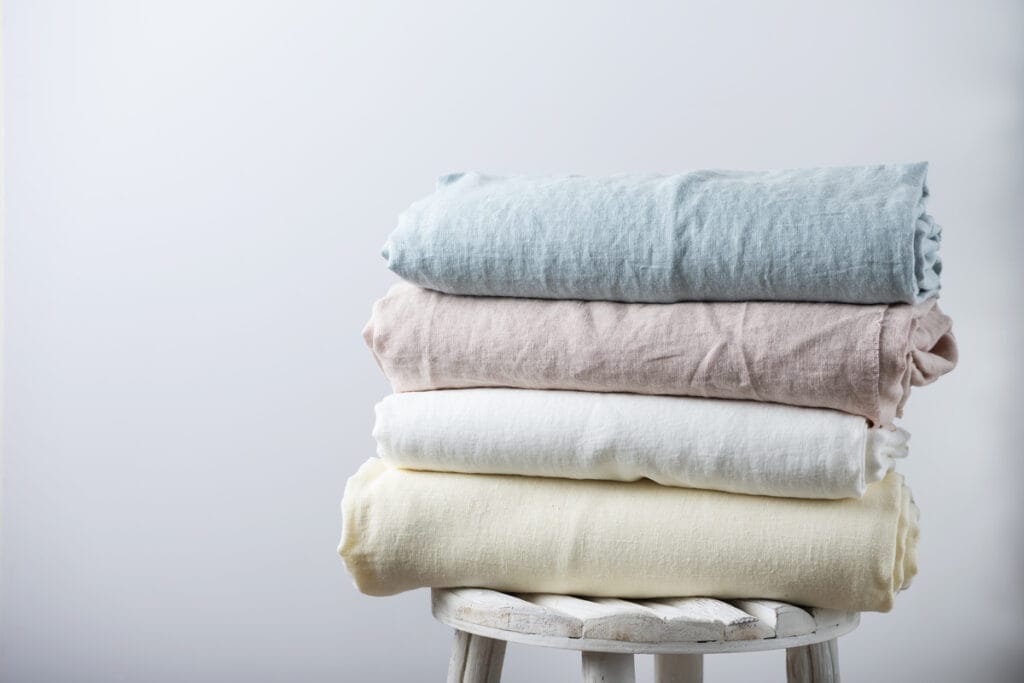 A stack of bamboo fabric folded towels on a stool