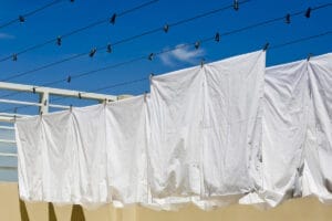 White bamboo bed sheets hanging outside for drying